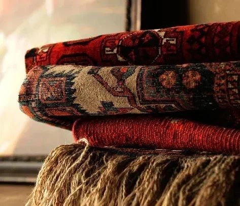 Close-up of a hand-woven Persian carpet showing intricate patterns and detailed craftsmanship.