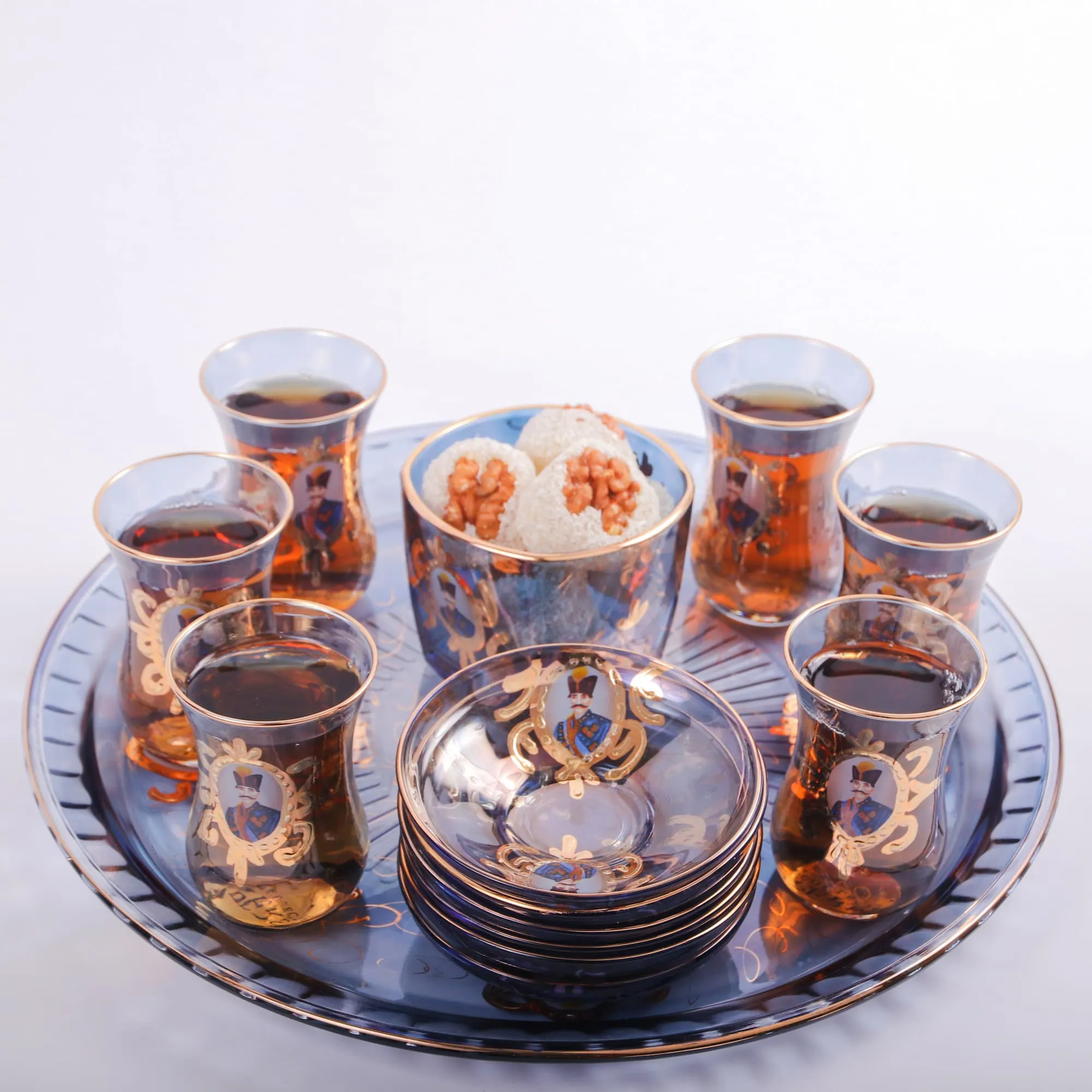 Elegant tea service set with teapot, cups, and saucers on a decorative tray.