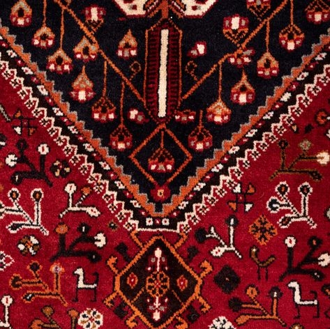 Qashqai rug with intricate red and blue patterns, featuring a central medallion design.