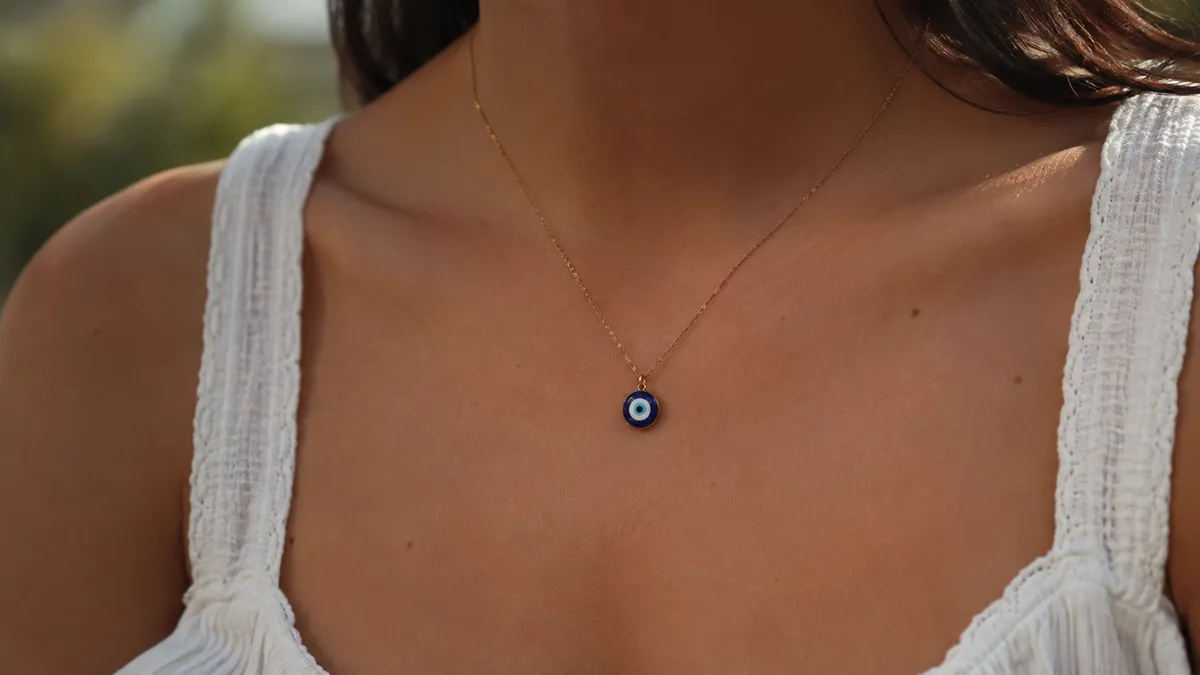 A person wearing an evil eye pendant necklace